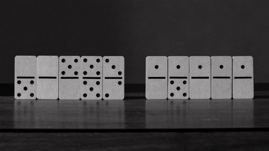 一列に並んだドミノと、途中の切れ目（白黒写真）