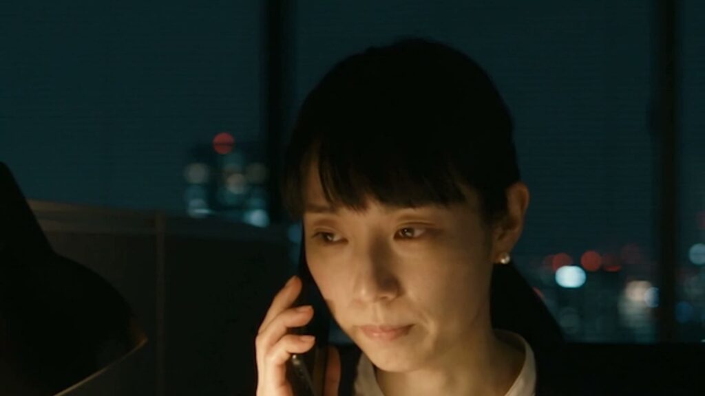 AIドラマ『派遣監査人』で、夜のオフィスで佐倉が電話をしている場面